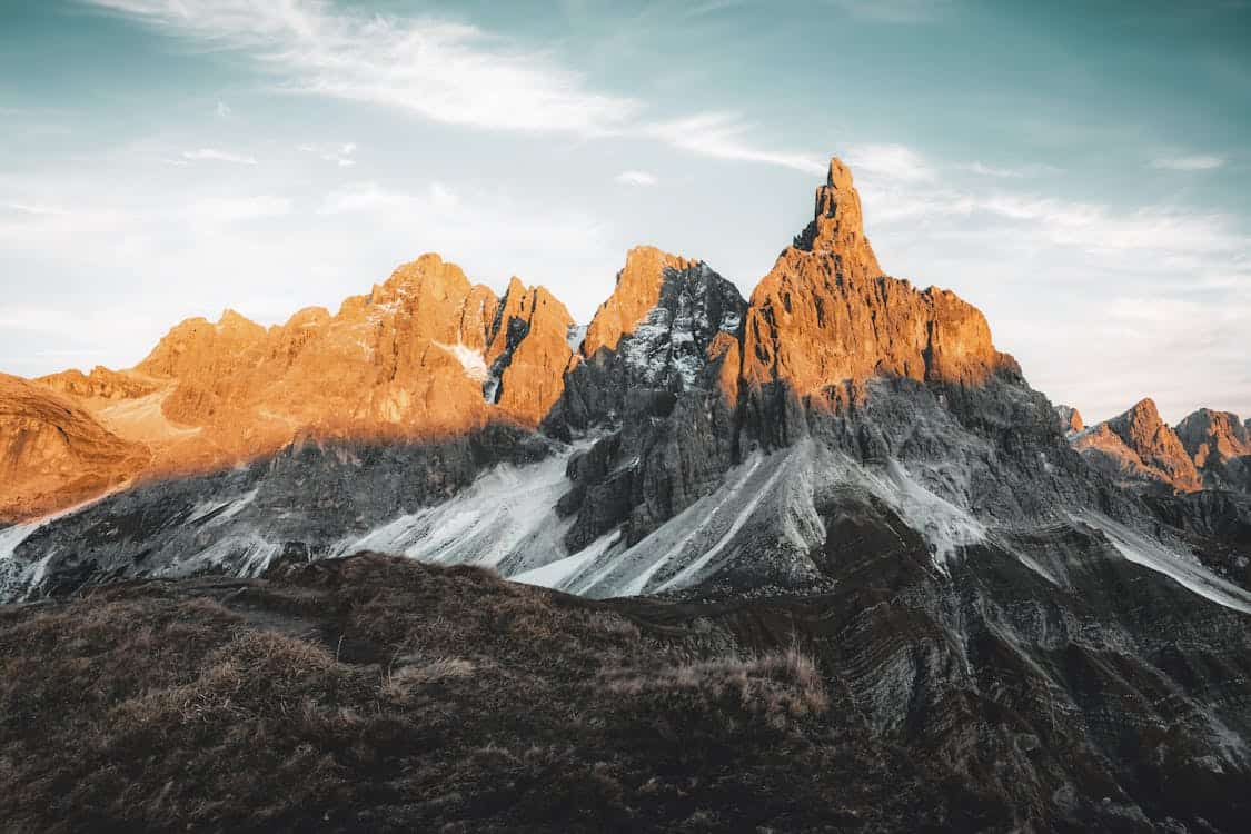 Montagnes majestueuses au coucher du soleil avec des roches escarpées.